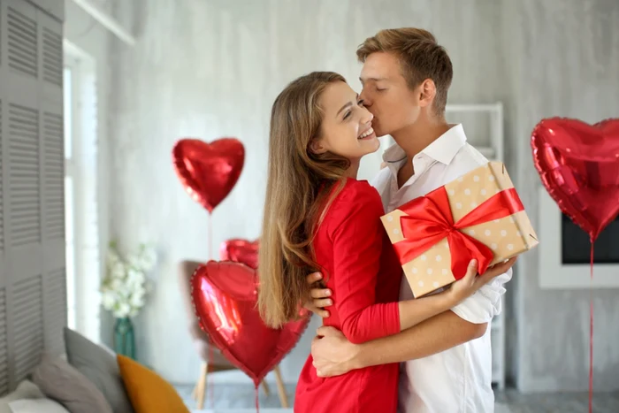 A young man kisses his girlfriend