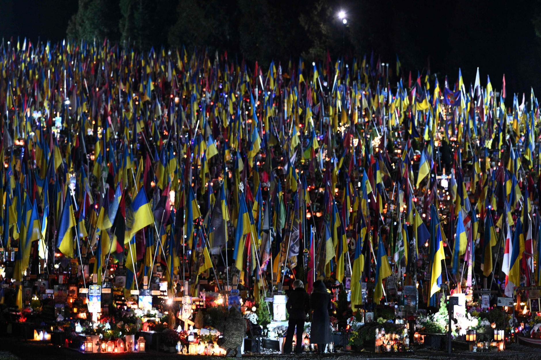 People visit the graves of fallen Ukrainian soldiers on the eve of All Saints' Day at the Lychakiv Cemetery in Lviv, October 31, 2025.