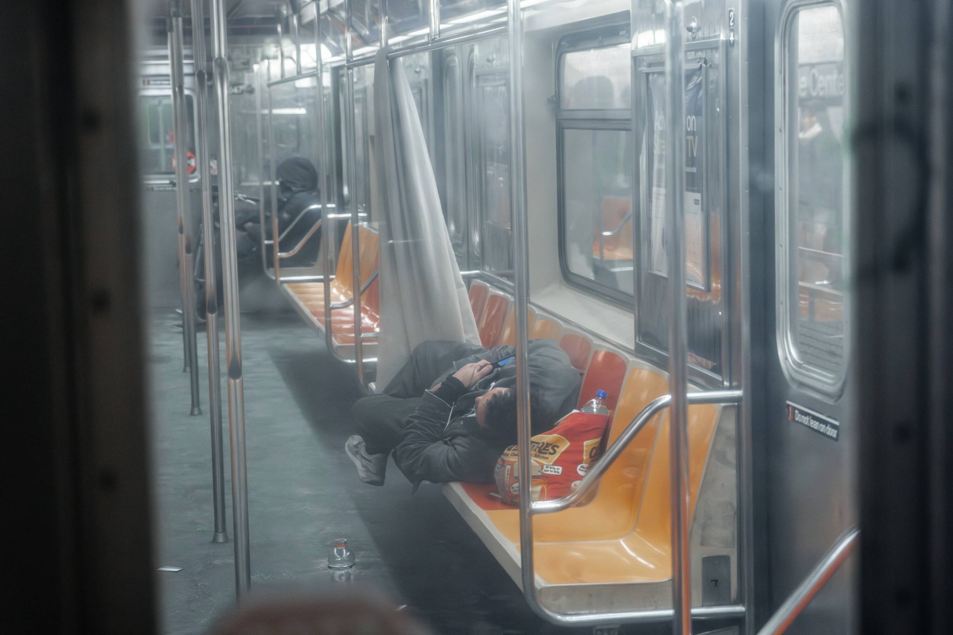 A person in crisis of homelessness sleeps in a subway car during freezing weather in New York, U.S., February 7, 2026. 