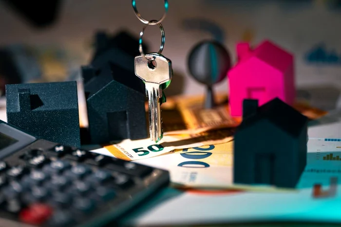 Photo collage with models of houses, a computer and a key