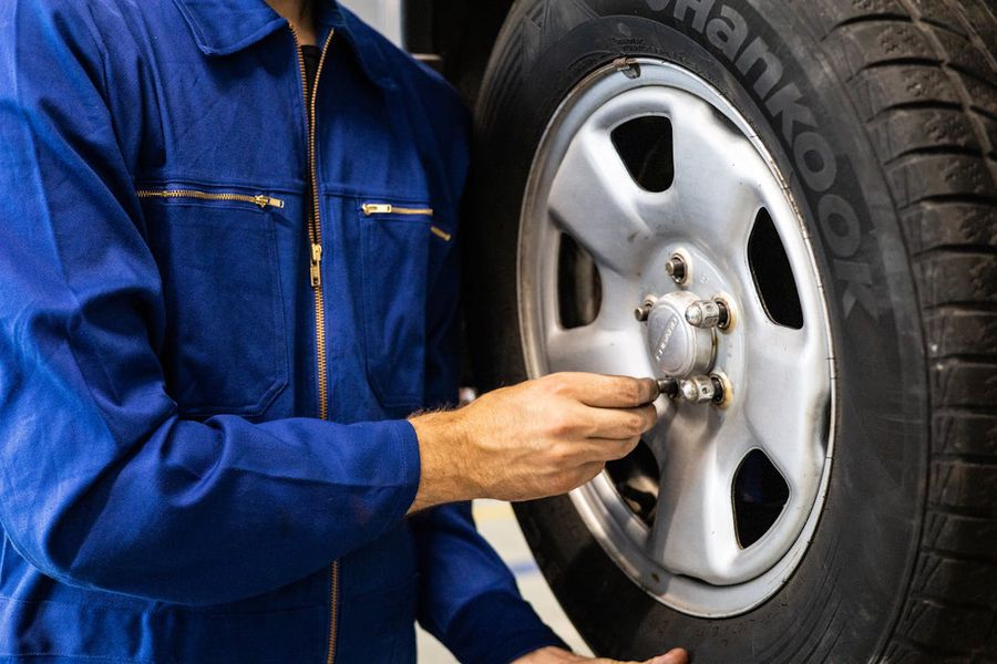 Why is it important to check tire wear and how do you do it?