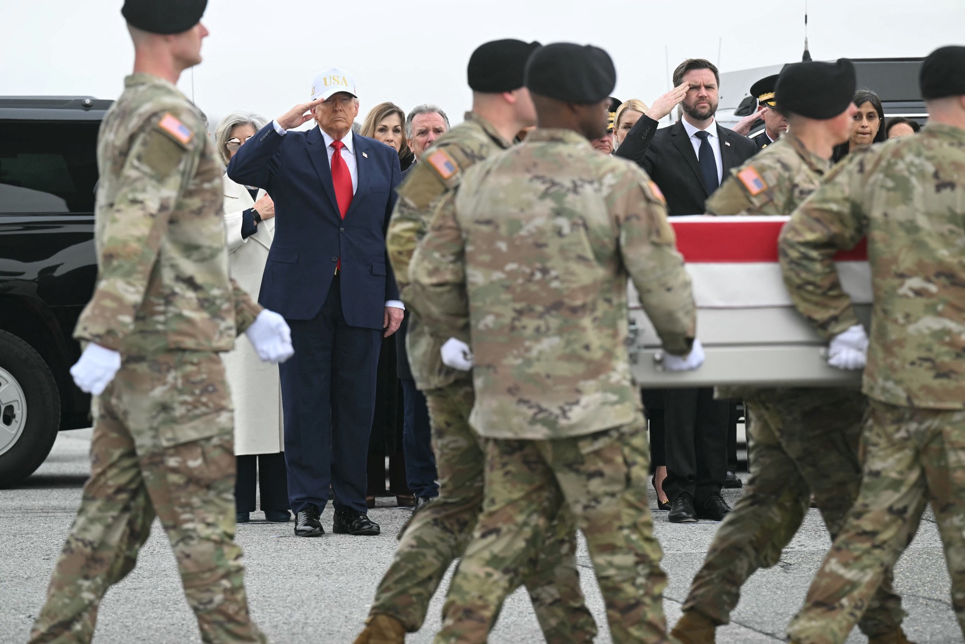 United States President Donald Trump and Vice President J.D. Vance salute as members of a U.S. Army band carry a flag-draped casket containing the remains of an American soldier killed in Iran, March 7, 2026.