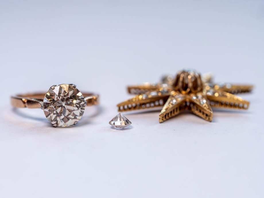 A ring with a 3-carat diamond and a gold pendant studded with diamonds.