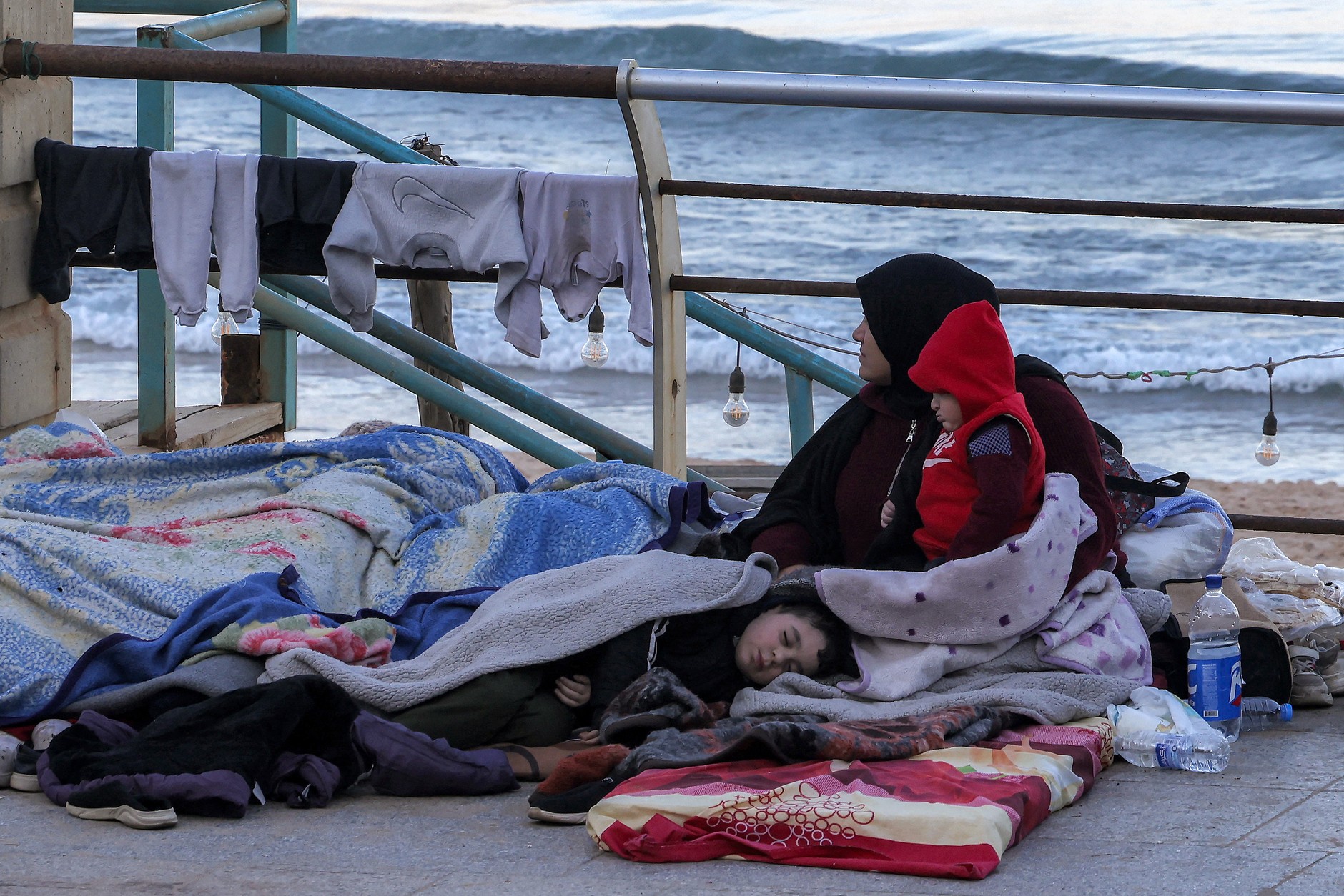 A woman with children in a makeshift camp on the seafront in Beirut after fleeing southern suburbs due to Israeli bombing, Lebanon, March 10, 2026.