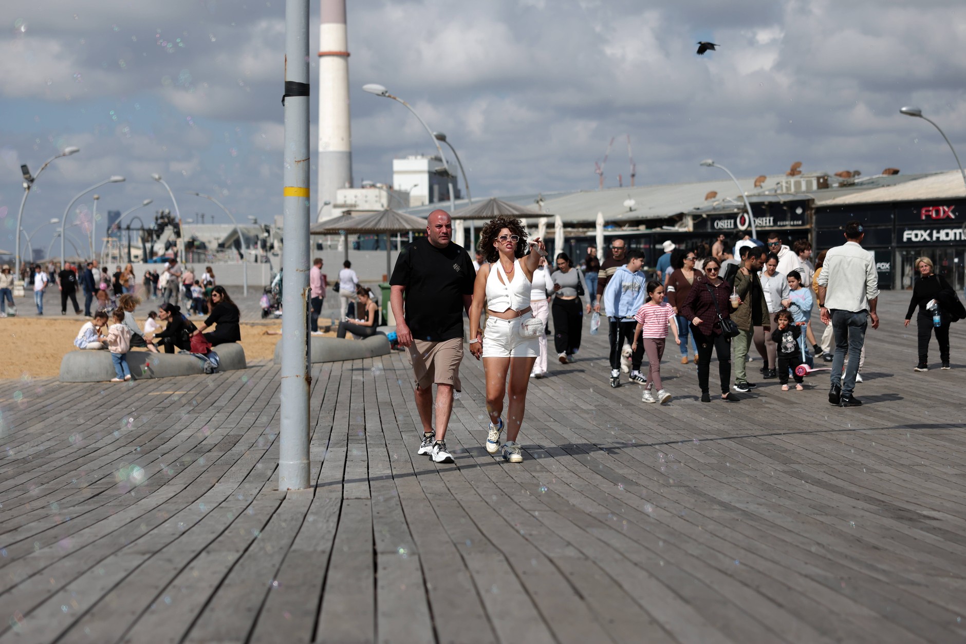   People walk along the wooden promenade, enjoying a spring day on the beach in Tel Aviv. Photo from April 8, 2026