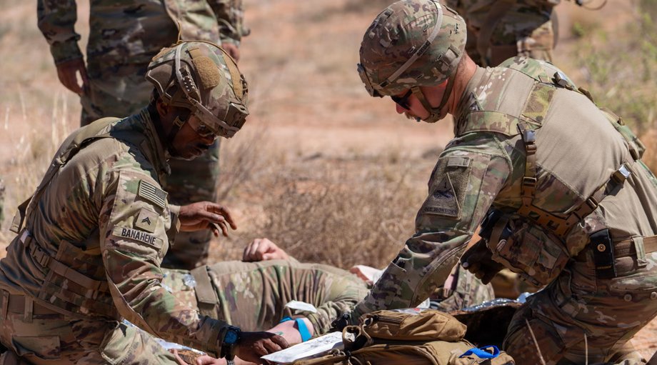 US soldiers place intravenous access on a simulated victim in preparation for air evacuation during a training exercise at Fort Bliss, Texas